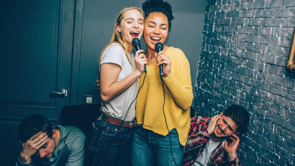 Funny Friends Making Fun at Karaoke Night while Other Can't bear their Bad Voices